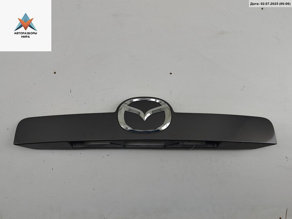 накладка подсветки номера Mazda CX-7 1 поколение 2007, 2.3 л., бензин, МКПП, серый, внедорожник 5 дв., EG2150811 - фото №1